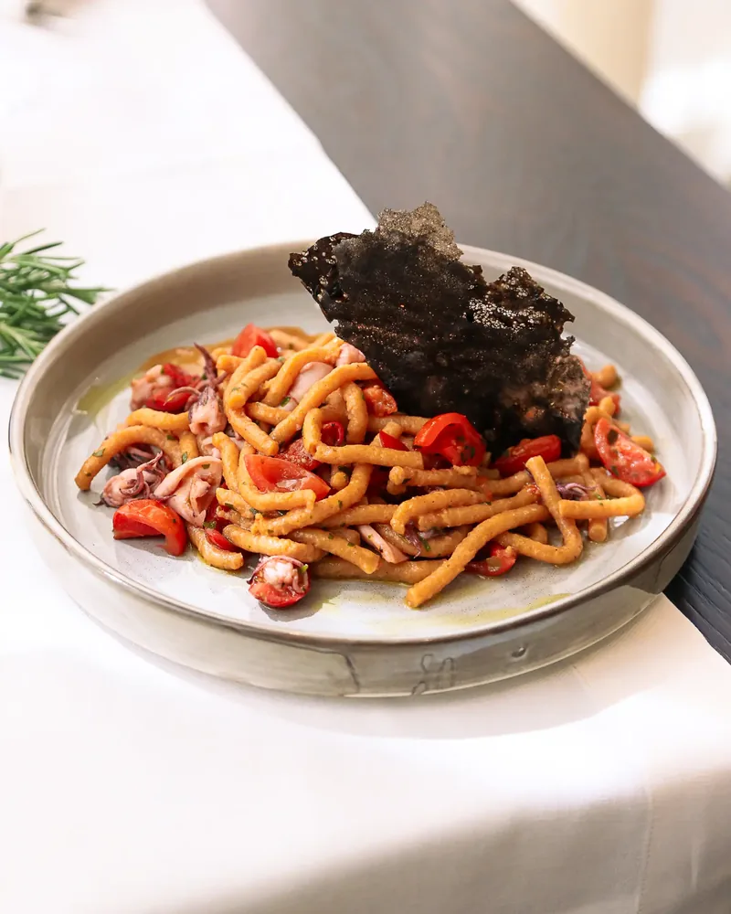 Passatelli con calamaretti, pomodorini, limone e cialda al nero di seppia